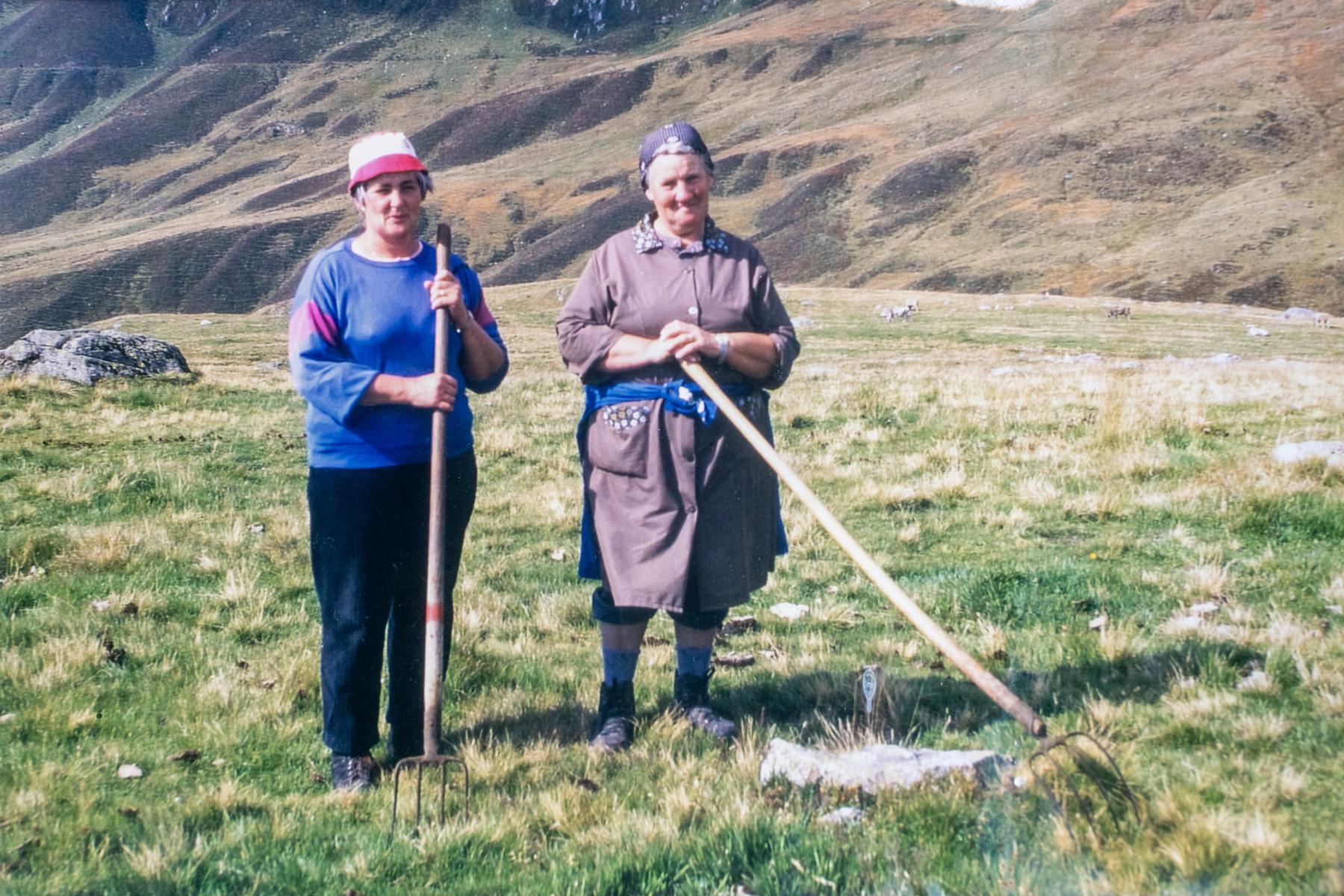 Frauen beim Alpwerk auf der Alp Bäll. Die Kuhfladen auf der Alpweide werden von Hand mit
der Heugabel zerkleinert und zum Düngen der Wiese verteilt, ca. 1980.