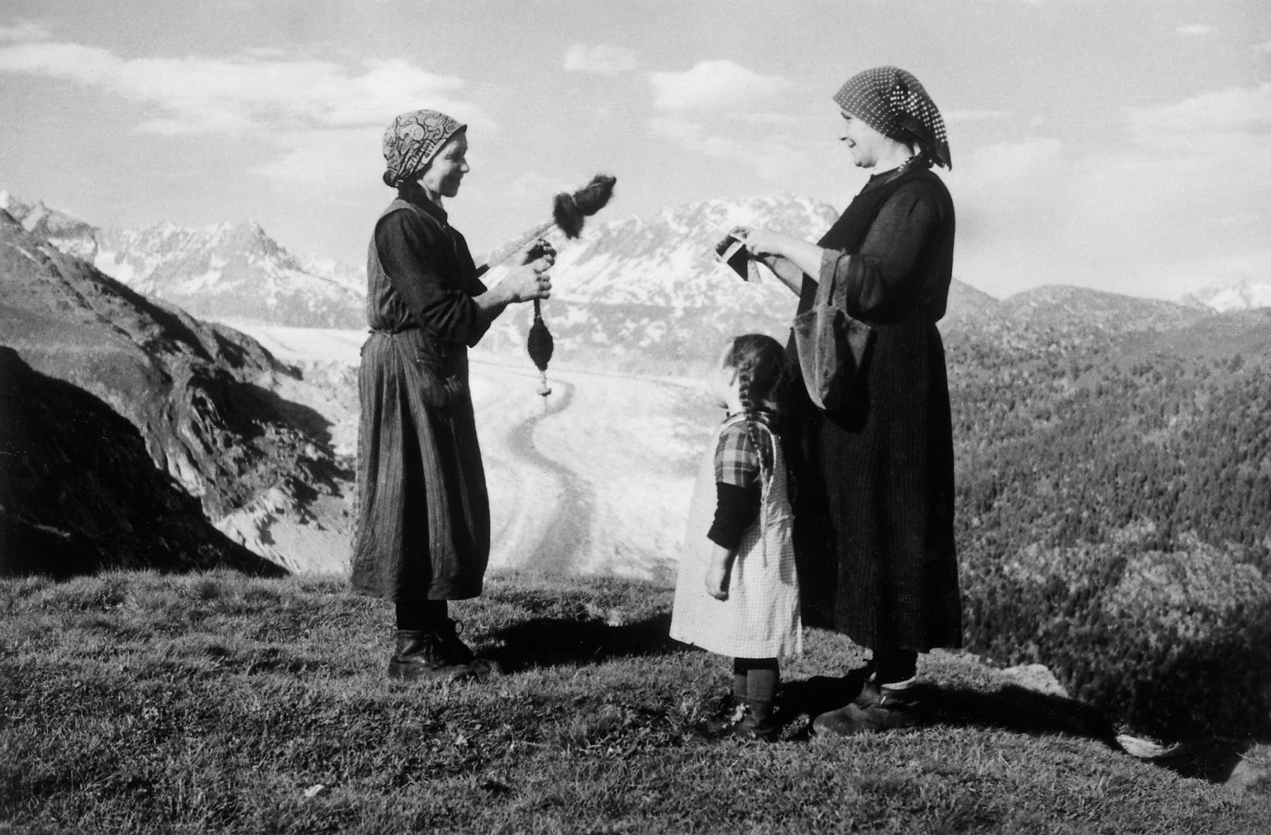 Kreszentia Eggel am «spinnu» und Klara Wyssen-Michlig am «lismu» auf der Alp Lüsga.