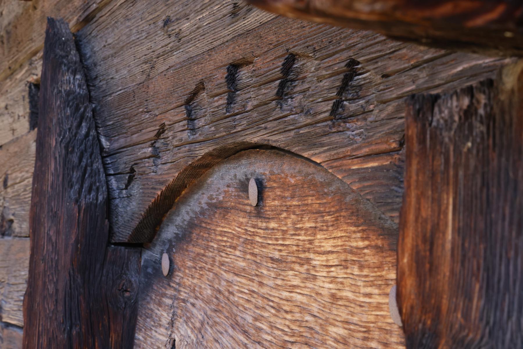 Ins Holz geschnitzte Verziehrungen an den Türbögen.